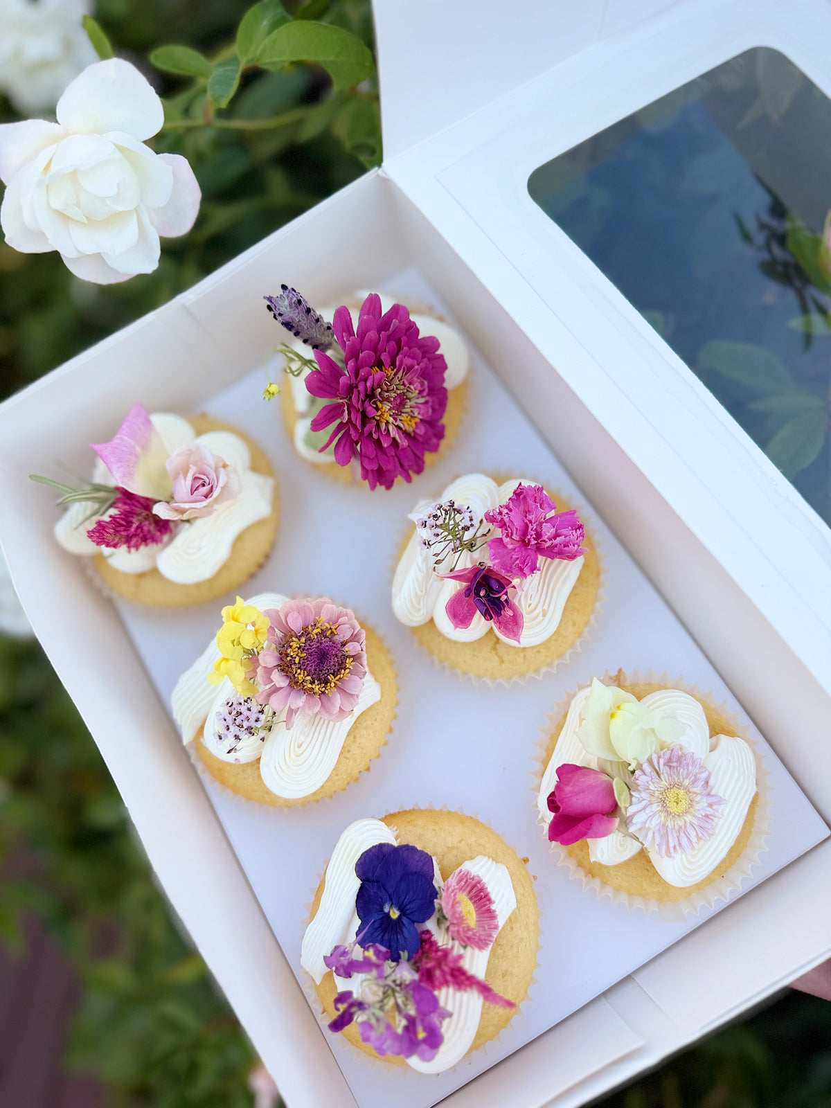 6 Cupcakes decorated with pastel freeze dried edible flowers.