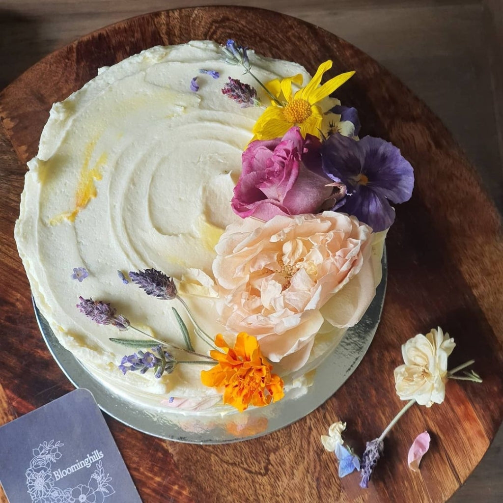 Vegan and gluten free birthday cake covered in Bloomish edible flowers by Blooming Hills Cake.