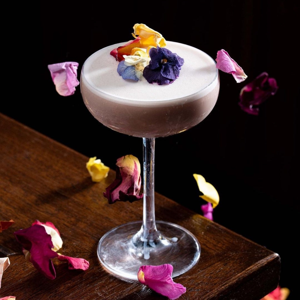 Beautiful cocktail by Stacked Social featuring Bloomish freeze dried edible rose petals.